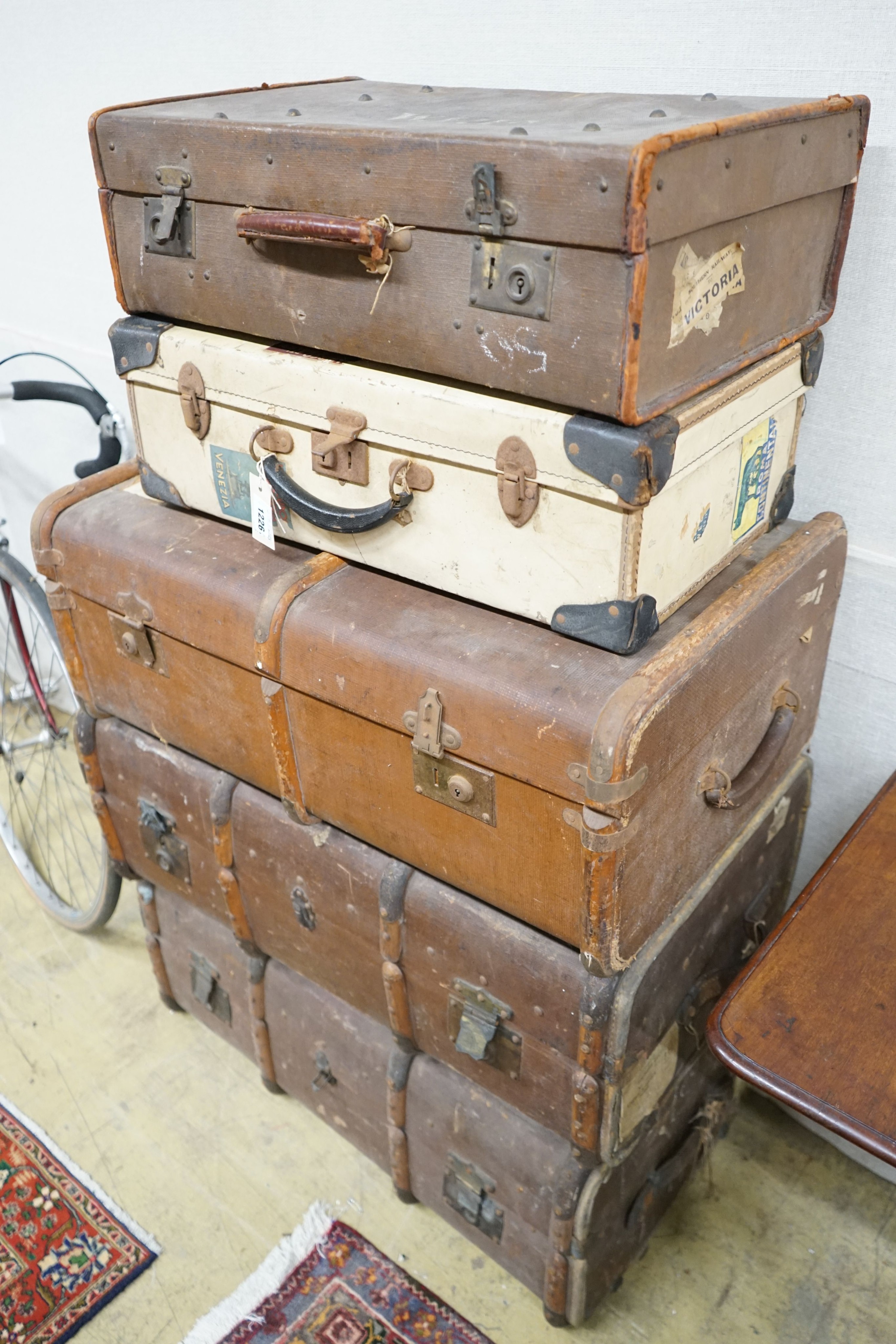 A collection of five vintage suitcases, largest width 83cm